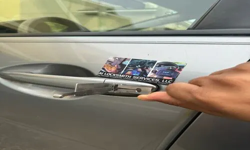 Person using a magnet on a car door handle to demonstrate a keyless entry system for automotive locksmith services.