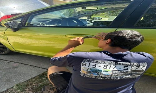 A man painting a yellow car, highlighting the importance of key cutting service for automotive locksmith needs.