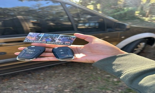 A person with two car keys in front of a vehicle, representing our Duplicate Key service for automotive locksmith assistance.