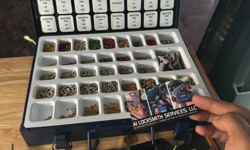 A person holding a card next to a small box of jewelry, representing locksmith service offerings for secure storage solutions.