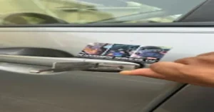 Hand unlocking a car door with a locksmith's business sticker visible on the side. When to call an automotive locksmith for quick and reliable assistance