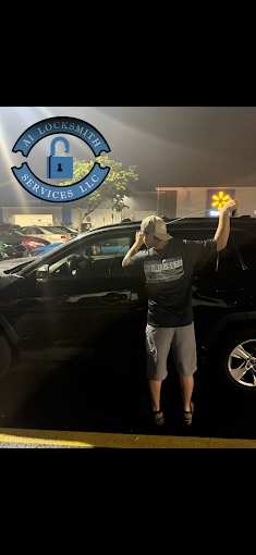 technician from A1 Locksmith Services, LLC, posing next to a black car in a parking lot, showcasing the locksmith services provided for automotive needs