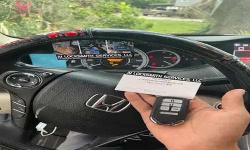 Alt Text: A1 Locksmith Services LLC technician holding a newly programmed Honda car key fob inside a vehicle, showcasing professional automotive locksmith expertise.