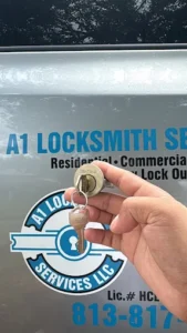 A1 Locksmith Services LLC technician holds a new lock cylinder and keys in front of a company vehicle, showcasing professional commercial lock repair service.