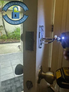 A1 Locksmith Services LLC technician uses a power drill to rekey a residential door lock, demonstrating expert residential lock rekeying service for homeowners.