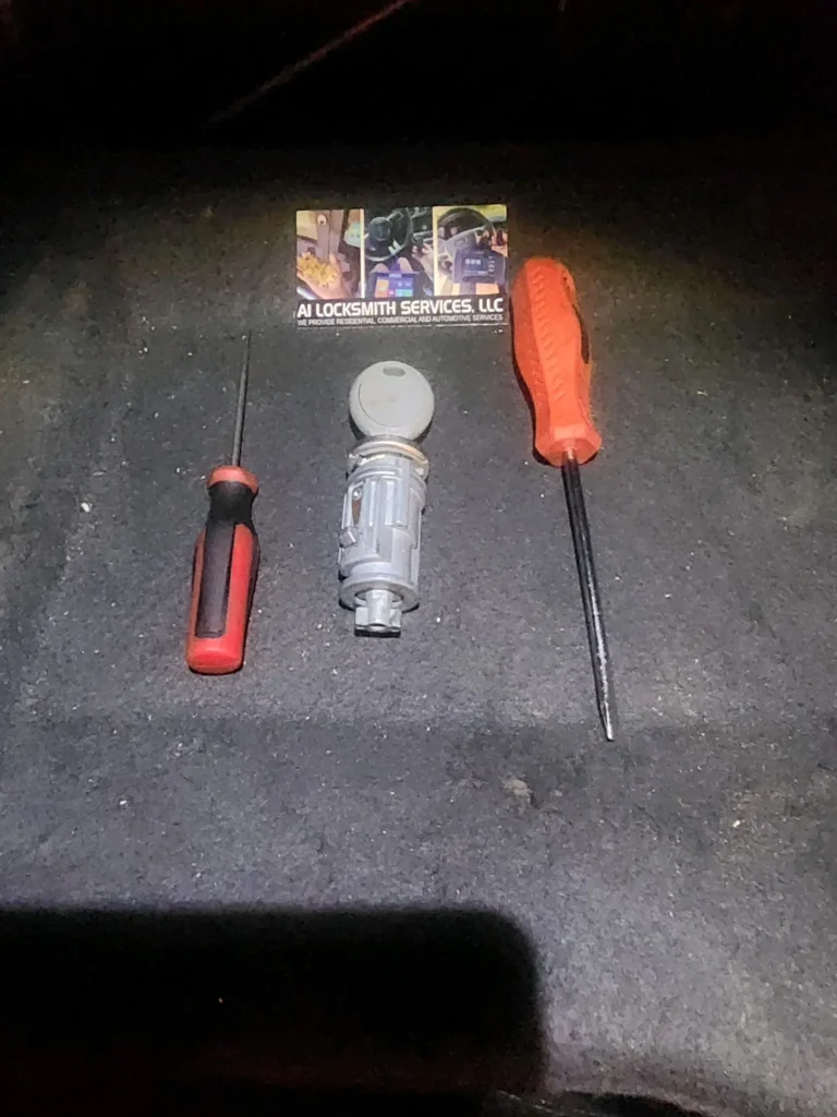 Locksmith tools and a lock cylinder placed beside an A Locksmith Services LLC business card, representing professional residential lock installation service.