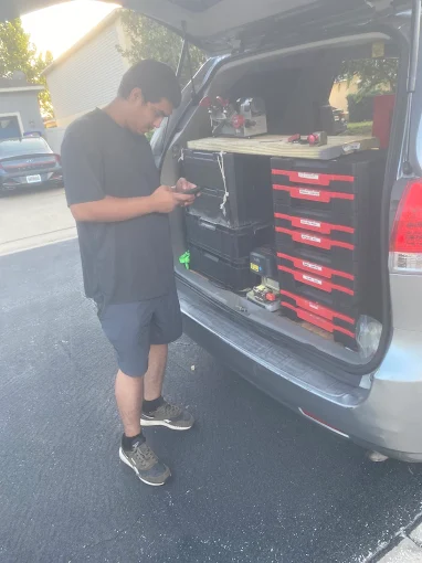 A locksmith from A1 Locksmith Services LLC standing beside a work van equipped with organized tool drawers and supplies, representing professional residential lock installation service.