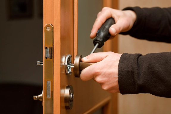 Locksmith Services for repairing and installing a door lock with a screwdriver