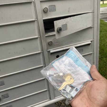 A residential locksmith with a key in hand, preparing to open a mailbox for lock reppair near Riverview, FL.