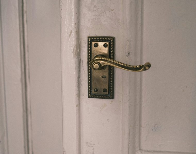 A modern door handle on a white door, showcasing residential locksmith services for home security in Riverview.